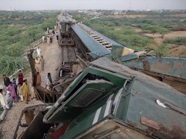 Residents stand near the wagons of a passenger train after it collided with another in Karachi leaving one dead and many injured. Reuters photo