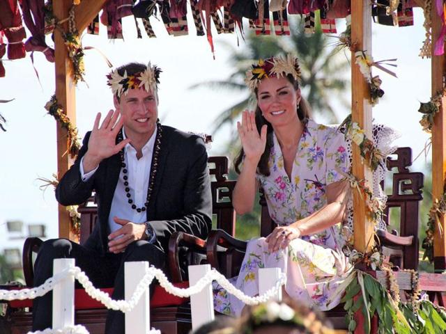 Britain's Prince William and his wife Catherine, the Duchess of Cambridge, wave as they sit on a platform while being carried to the plane for his farewell with wife Catherine from Tuvalu in Funafuti. AFP Photo