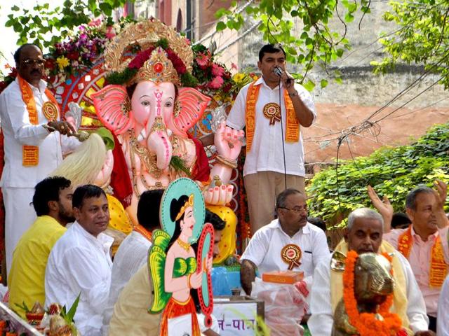 The idol of Lord Ganesha being brought in a ceremonial procession for installation at a pandal by Sri Ganesh Seva Mandal, Laxmi Nagar, in New Delhi.
