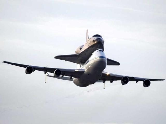 Space shuttle Endeavour atop a modified jumbo jet makes its departure from the Kennedy Space Center in Cape Canaveral, Florida. Endeavour will make a stop in Houston before heading to the California Science Center in Los Angeles.(AP/Terry Renna)