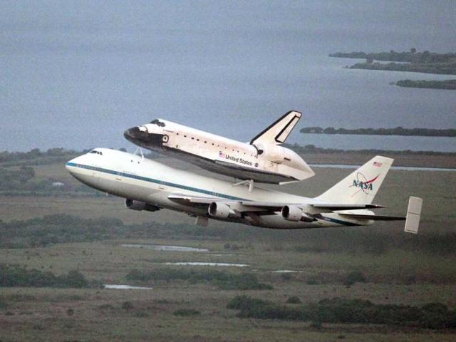 Space shuttle Endeavour, bolted atop a modified jumbo jet, makes its departure from the Kennedy Space Center in Cape Canaveral, Florida. (AP Photo/John Raoux)