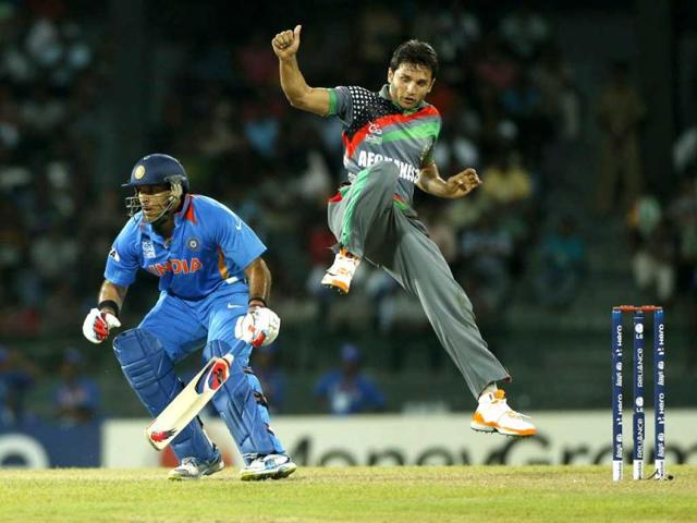 Yuvraj Singh, left, tries to run between wickets as Afghanistan's bowler Gulbodin Naib jumps during their ICC Twenty20 Cricket World Cup match in Colombo, Sri Lanka. AP/Eranga Jayawardena