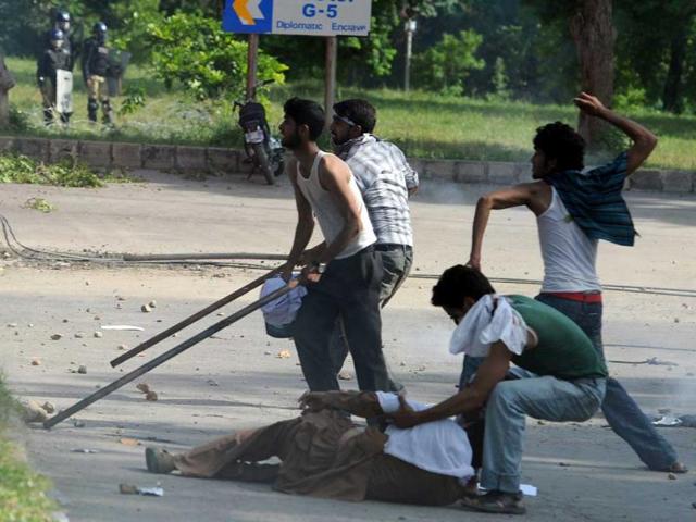 A Pakistani student drags a colleague as others hold and throw pojectiles at riot police as they attempt to reach the US embassy during a protest against an anti-Islam film in Islamabad. AFP/Aamir Qureshi