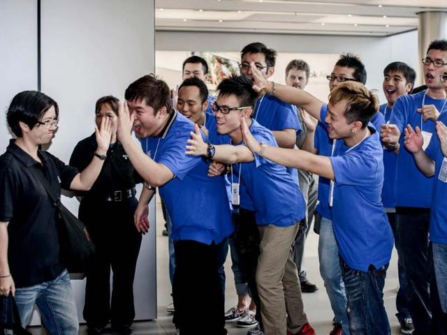 A customer is greeted by Apple employees as she enters the Hong Kong Apple store to get an iPhone 5. Apple's iPhone 5 hit stores in Hong Kong with queues of fans undeterred by a lukewarm welcome from experts for the smartphone and complaints about its new mapping system. AFP/Philippe Lopez