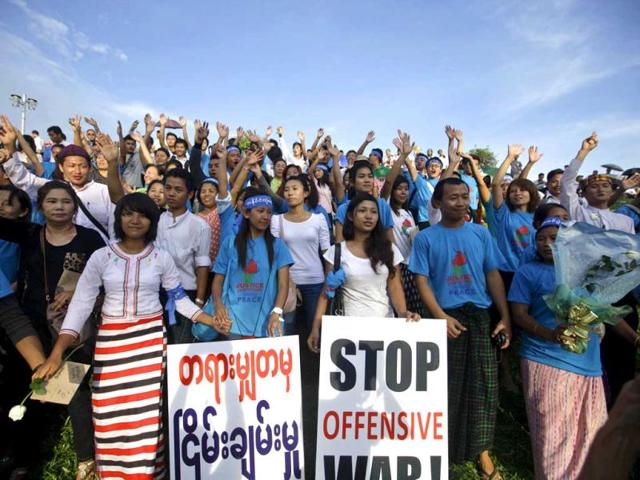 Ethnic Kachin people wave their hands at a ceremony to mark the International Day of Peace in Yangon. Hundreds of people, including farmers and members from various ethnic groups, participated in the march against civil war. Reuters photo