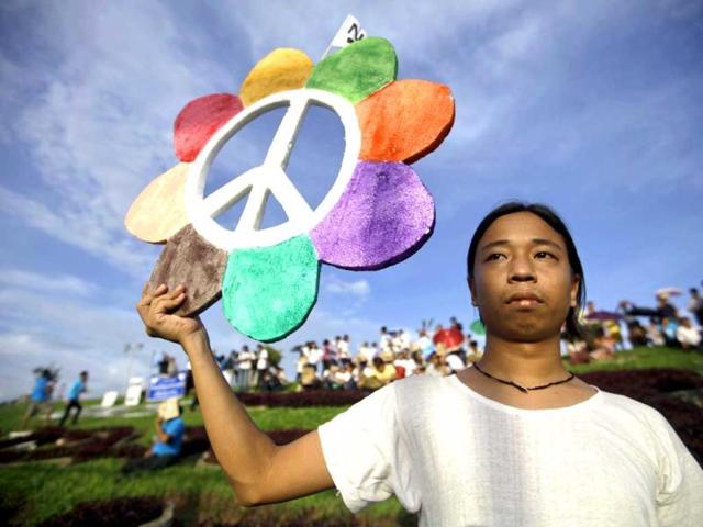 A man holds up a sign during a ceremony to mark the International Day of Peace in Yangon. Hundreds of people, including farmers and members from various ethnic groups, participated in the march against civil war. Reuters photo