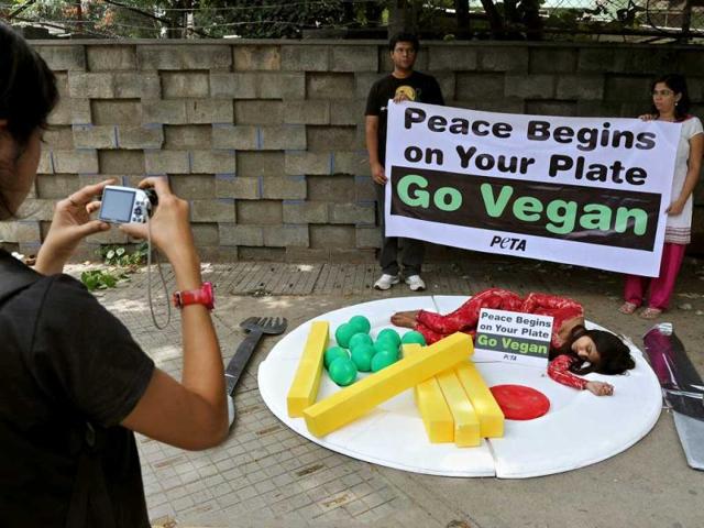 An onlooker takes a photograph of a People for the Ethical Treatment of Animals activist attired to look like a pice of meat within a meal as she lies on a huge plate during a demonstration in Bangalore to mark the International Day of Peace. AFP photo