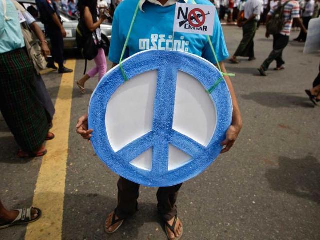 A man hangs the peace sign around his neck during a march against civil war to mark the International Day of Peace in Yangon. Reuters photo