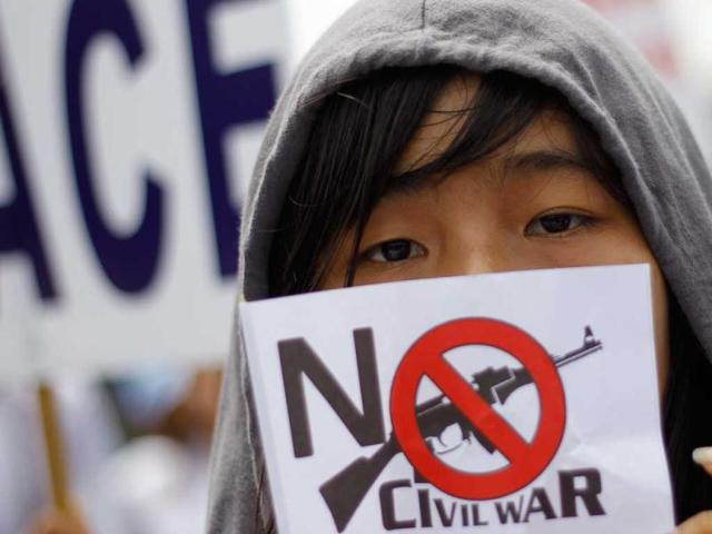 A woman holds a flag during a march against civil war to mark the International Day of Peace in Yangon. Reuters photo