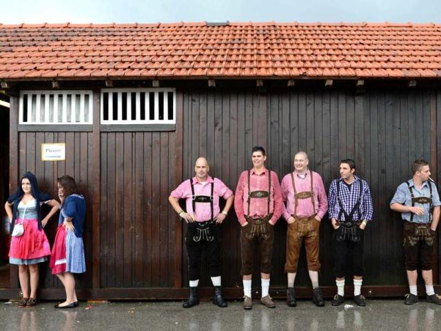 Visitors wearing traditional Bavarian clothes wait during the Oktoberfest beer festival at the Theresienwiese in Munich, southern Germany. This year's edition of the world's biggest beer festival Oktoberfest will run until October 7, 2012. AFP PHOTO / CHRISTOF STACHE
