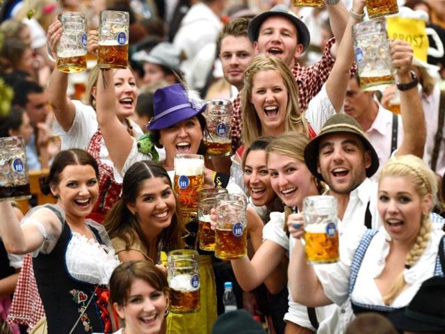 Visitors wearing traditional Bavarian clothes raise their beers in a festival tent at the start of the Oktoberfest beer festival at the Theresienwiese in Munich, southern Germany. AFP PHOTO / CHRISTOF STACHE