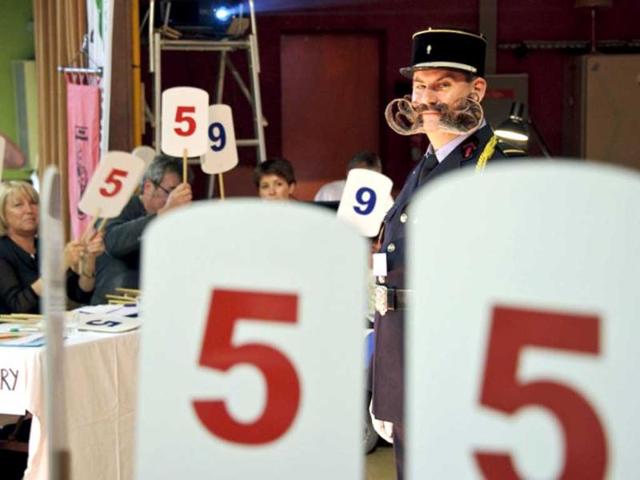 Jury members vote as a competitor stands on stage during the first edition of the European Beard and Moustache championships in Wittersdorf, eastern France. (AFP photo/Sebastein Bozon)