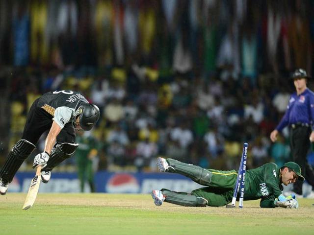 Pakistan wicket keeper Kamran Akmal (R) successfully runs out New Zealand captain Ross Taylor (L) during the ICC Twenty20 Cricket World Cup match between Pakistan and New Zealand at the Pallekele International Cricket Stadium in Pallekele. AFP PHOTO/ Prakash Singh