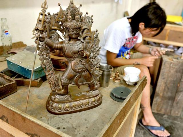 A traditional Tibetan craftsman hand sculpts a metal figurine of the Buddha at the Norbulingka Institute near Dharamshala. The Norbulingka Institute is a centre for arts dedicated to the preservation of Tibetan art and culture. (AFP Photo)