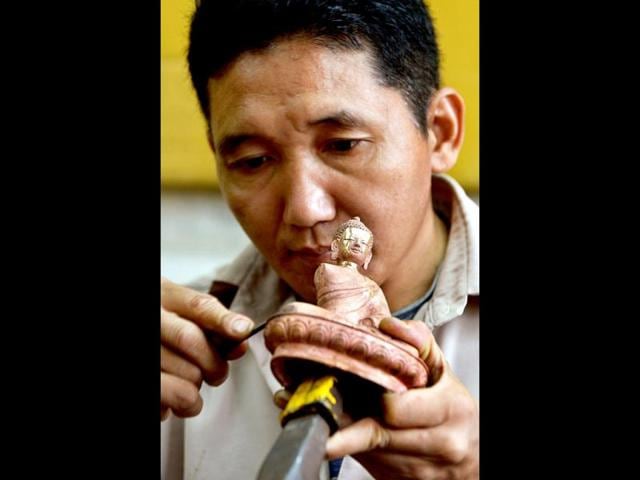A traditional Tibetan craftsman hand sculpts a metal figurine of the Buddha at the Norbulingka Institute near Dharamshala. The Norbulingka Institute is a centre for arts dedicated to the preservation of Tibetan art and culture. (AFP Photo)