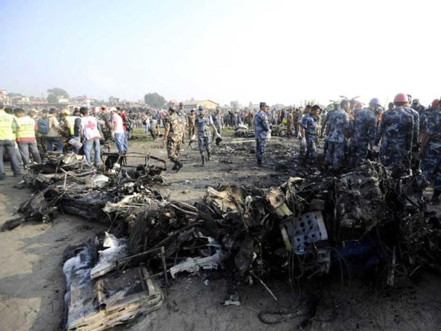 Onlookers and rescuers are seen near the wreckage of an Sita Air Dornier plane crash site in Manohara, on the outskirts of Kathmandu. AFP/Prakash Mathema
