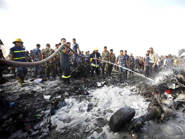 A rescue team member hoses down the crash site of a Dornier aircraft in Kathmandu. Reuters/Navesh Chitrakar