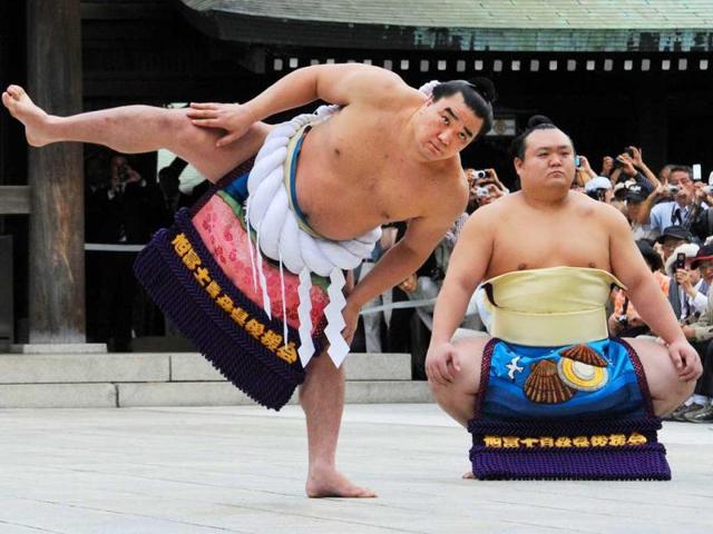 Accompanied by sumo wrestler Takarafuji (R), new yokozuna, or grand champion, Harumafuji performs the ceremonial entrance into the ring at Meiji Shrine in Tokyo. The Mongolian sumo wrestler was promoted to the highest rank 'yokozuna'. AFP PHOTO / Rie ISHII