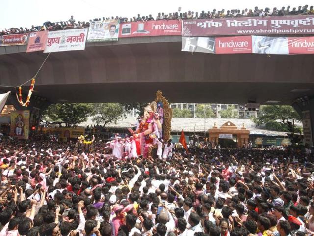 Devotees gather around a huge idol of the Lord Ganesha during the procession for immersion into the Arabian Sea, at Lalbaugh in Mumbai.(HT Photo by Kunal Patil)