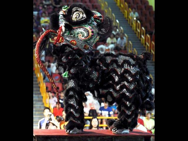 Hong Kong team members perform a lion dance during the world championships in Hong Kong. A total of eight teams take part in the lion dance which is a form of traditional dance in Chinese culture, in which performers mimic a lion's movements in a lion costume. (AFP photo/Laurent Fievet)