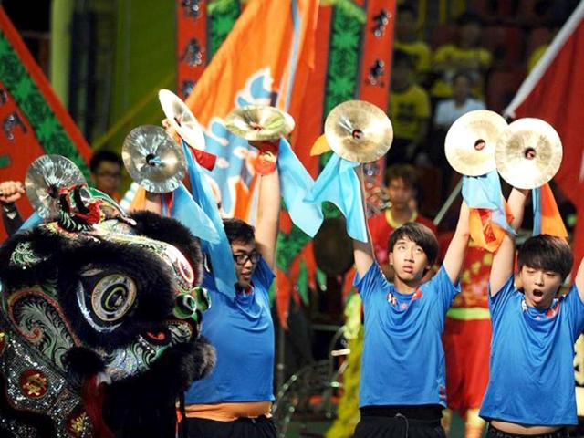 Hong Kong team members play percussion and perform a lion dance during the world championships in Hong Kong. A total of eight teams take part in the lion dance which is a form of traditional dance in Chinese culture, in which performers mimic a lion's movements in a lion costume. (AFP photo/Laurent Fievet)
