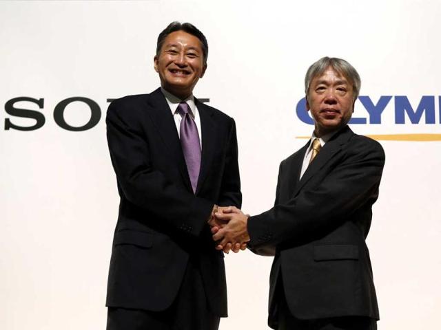 Sony Corp's president and chief executive officer Kazuo Hirai (L) and Olympus Corp's president Hiroyuki Sasa shake hands after their joint news conference in Tokyo. Reuters Photo