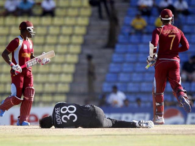 New Zealand's bowler Tim Southee, center, falls on the ground in an attempt to stop the ball as West Indies' batsmen Darren Bravo, left, and Marlon Samuels run between the wickets to add runs during their ICC Twenty20 Cricket World Cup Super Eight match in Pallekele. (AP Photo/Aijaz Rahi)