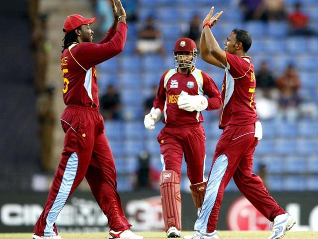 West Indies' bowler Samuel Badree, right, celebrates with teammate Chris Gayle, left, the dismissal of New Zealand's batsman Brendon McCullum, not seen, during the ICC Twenty20 Cricket World Cup Super Eight match in Pallekele, Sri Lanka. (AP Photo/Aijaz Rahi)