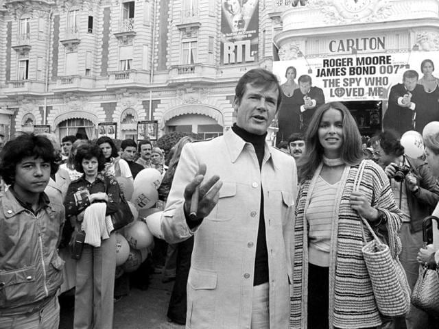 In this May 20, 1977 file photo, actor Roger Moore, alias British secret agent James Bond, is accompanied by co-star Barbara Bach as they arrive for the screening of their latest 007 feature, "The Spy Who Loved Me," during the Cannes Film Festival at the French Riviera. Moore, played Bond in seven films, more than any other actor. (AP Photo, File)