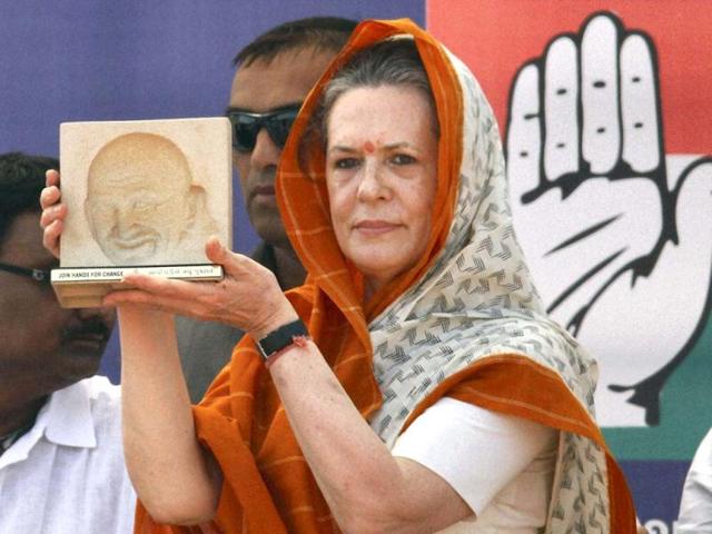 Congress president Sonia Gandhi receives a memento at an election campaign rally in Rajkot. PTI photo