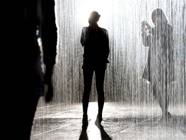 Visitors walk through an art installation entitled "Rain Room" during a photocall at the Barbican in London AFP/Leon Neal