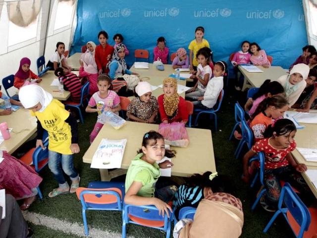 Young Syrian refugees sit at a UNICEF-run school in the al-Zaatari refugee camp in the Jordanian city of Mafraq near the border with Syria. The school is a grant from the European Union to provide education to Syrian refugees residing in Jordan. AFP/Khalil Mazraaw