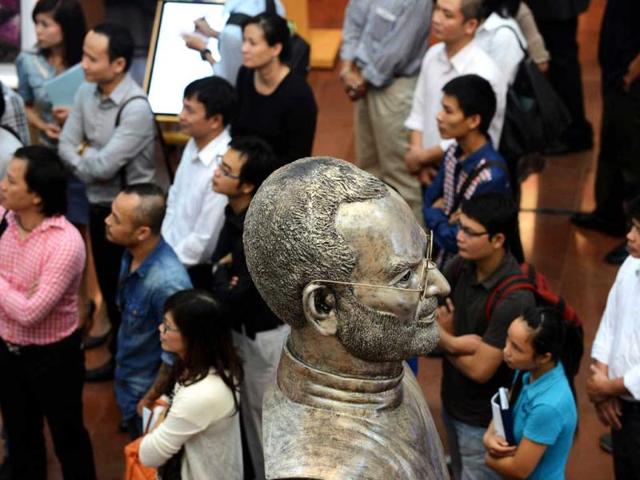 A bust of Steve Jobs looms over visitors at the opening ceremony of at an art exhibition in commemoration of the late Apple's co-founder Steve Jobs on the occasion of his first death anniversary in Hanoi. AFP Photo/Hoang Dinh Nam