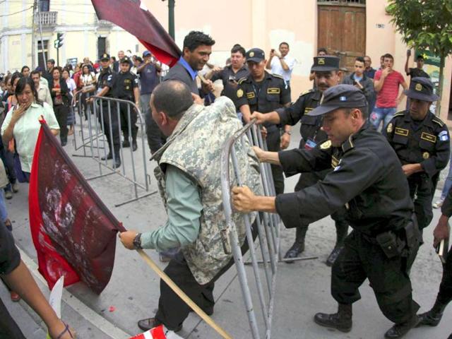 Protesters push against a security fence set up by the police as they take part in a demonstration outside the Casa Presidencial, or Presidential House, in Guatemala City. (Reuters/Jorge Dan Lopez)