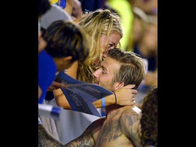 Los Angeles Galaxy's David Beckham, right, gets a hug from a fan following their MLS soccer match against Real Salt Lake in Carson, Calif. (AP Photo/Mark J. Terrill)
