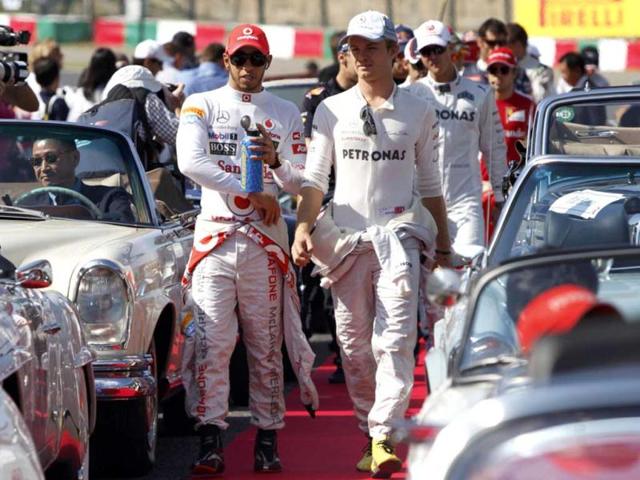 McLaren Formula One driver Lewis Hamilton (L) of Britain walks beside Mercedes Formula One driver Nico Rosberg of Germany before the drivers' parade of the Japanese F1 Grand Prix at the Suzuka circuit. Reuters/Issei Kato
