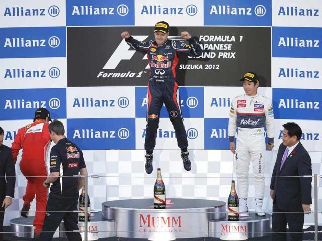 Red Bull driver Sebastian Vettel of Germany, center, celebrates on the podium after winning the Japanese Formula One Grand Prix, as third placed Sauber driver Kamui Kobayashi of Japan looks on, and second placed Ferrari driver Felipe Massa of Brazil climbs on to the podium, at the Suzuka Circuit in Suzuka, Japan. (AP Photo/Greg Baker) 