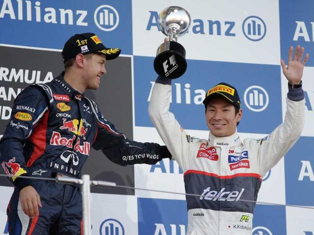 Race winner Red Bull driver Sebastian Vettel of Germany congratulates Sauber driver Kamui Kobayashi, right, of Japan after his third place finish the Japanese Formula One Grand Prix at the Suzuka Circuit in Suzuka. (AP Photo/Mark Baker) 