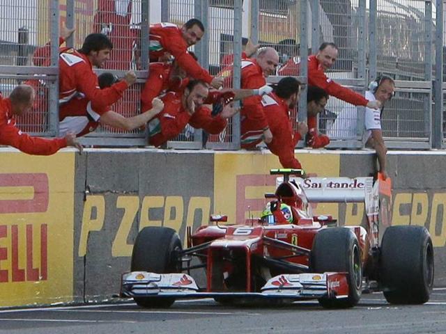 Ferrari driver Felipe Massa of Brazil celebrates in front of his team after crossing the line to finish second in the Japanese Formula One Grand Prix at the Suzuka Circuit in Suzuka. (AP Photo/Greg Baker) 