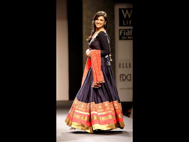 Clad in a beautiful navy blue-orange lehenga, teamed with a deep-cut choli and a heavy dupatta, chirpy and spontaneous actress Parineeti Chopra left the audience applauding and cheering when she walked the ramp for veteran designer Manish Malhotra at the ongoing Wills Lifestyle India Fashion Week. (Photo: Raj K Raj/ Hindustan Times)
