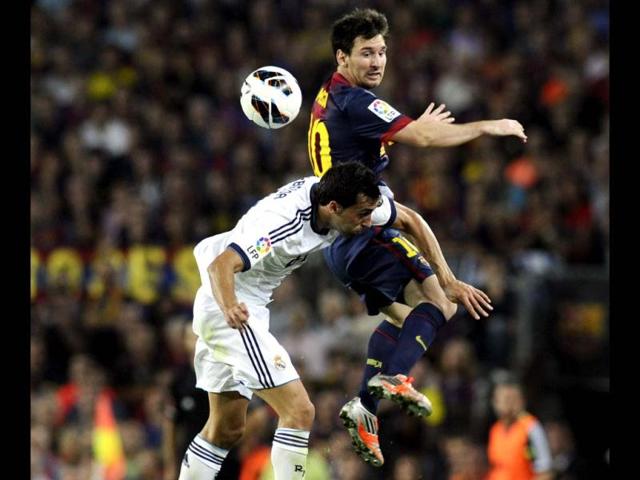 Barcelona's Lionel Messi and Real Madrid's Alvaro Arbeloa fight for the ball during their Spanish first division soccer match at Nou Camp stadium in Barcelona. (Reuters)