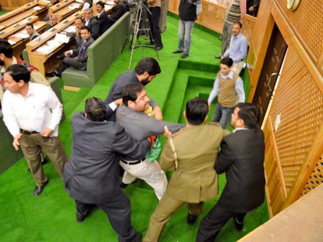 Watch and Ward staff take away a youth who entered Jammu and Kashmir assembly demanding implementation of employment policy, in Srinagar. PTI