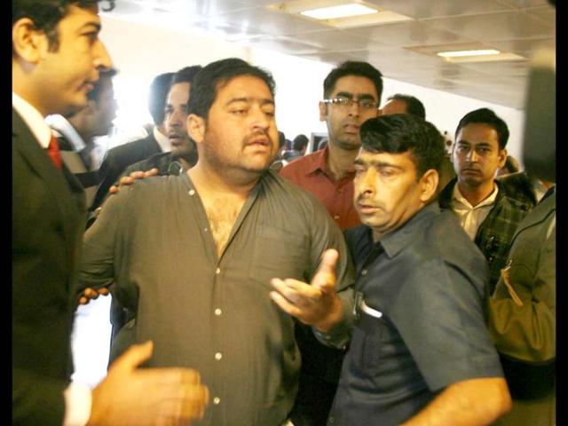 Security forces lead out a protester who had jumped into the main hall of the Jammu and Kashmir assembly while the question hour was in progress. UNI