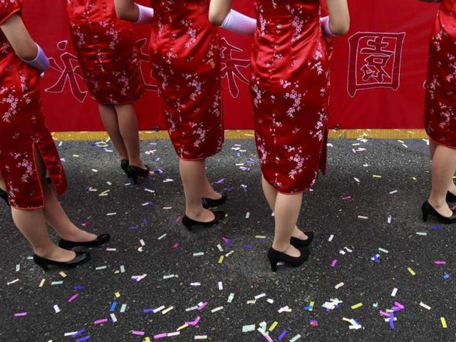 Presenters in traditional Chinese Chi Pao dresses wait on the sideline during National Day celebrations marking the 101st anniversary of the founding of the Republic of China in front of the Presidential Office in Taipei. AP Photo/Wally Santana