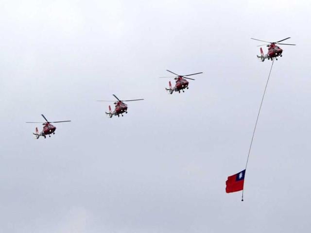 A team of rescue helicopters drag a Taiwanese national flag during National Day celebrations marking the 101st anniversary of the founding of the Republic of China, in front of the Presidential Office in Taipei, Taiwan. AP Photo/Chiang Ying-ying