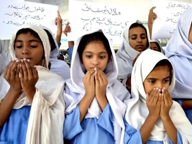 Pakistani school girls pray for the recovery of gunshot victim, Malala Yousafzai, in Multan. AFP / SS Mirza