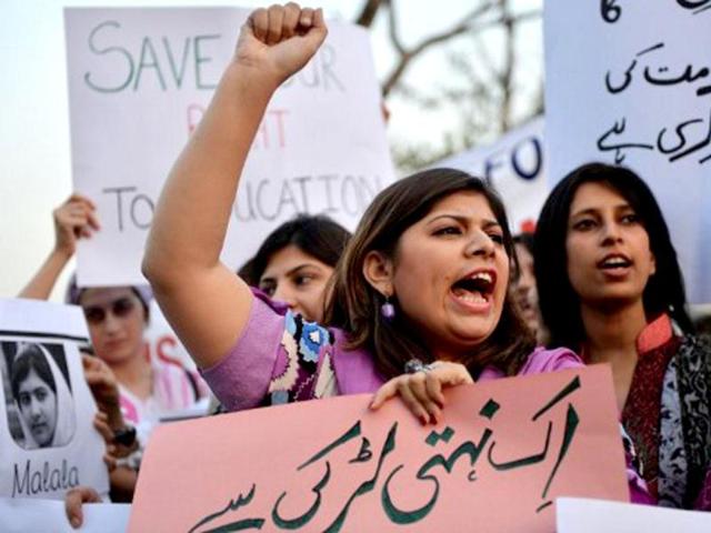 Pakistani civil society activists carry placards with a photograph of the gunshot victim Malala Yousafzai as they shout ant-Taliban slogans during a protest rally against the assassination attempt on Malala Yousafzai, in Islamabad .AFP / Aamir Qureshi
