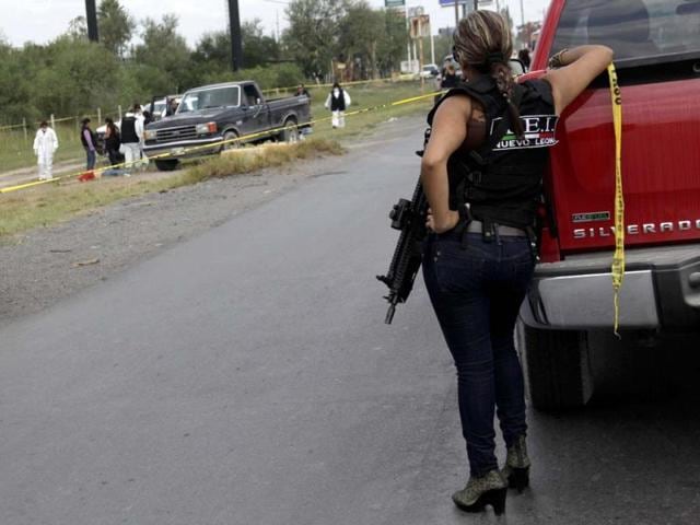 Police officers investigate near the dead body of a man at a crime scene in Apodaca. The man was shot dead by police after he had collected the payment of a ransom. Reuters Photo
