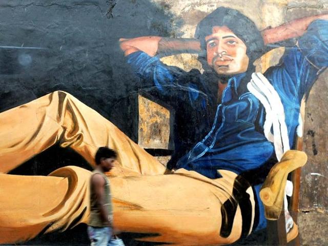 A man walks past a mural of Bollywood actor Amitabh Bachchan from his classic film Deewar on his 70th birthday. AFP photo