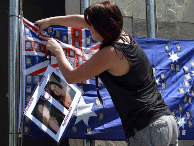 A girl attaches a picture of her friend to an Australian flag alongside other pictures of Australians who died during 2002 Bali bombing memorial monument, ahead of the 10-year anniversary of the incident in Kuta, Bali resort island, Indonesia. Reuters Photo
